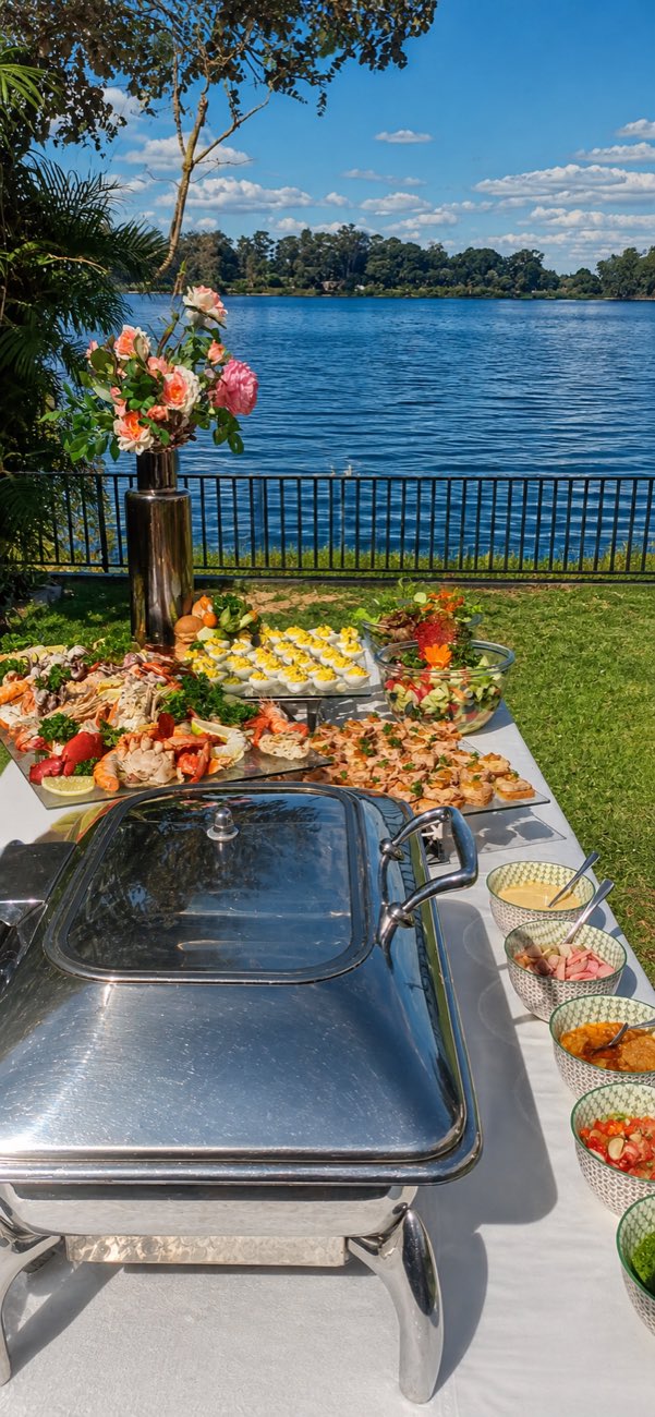 Buffet dressé au bord de l’eau, fleurs et vue sur le lac
