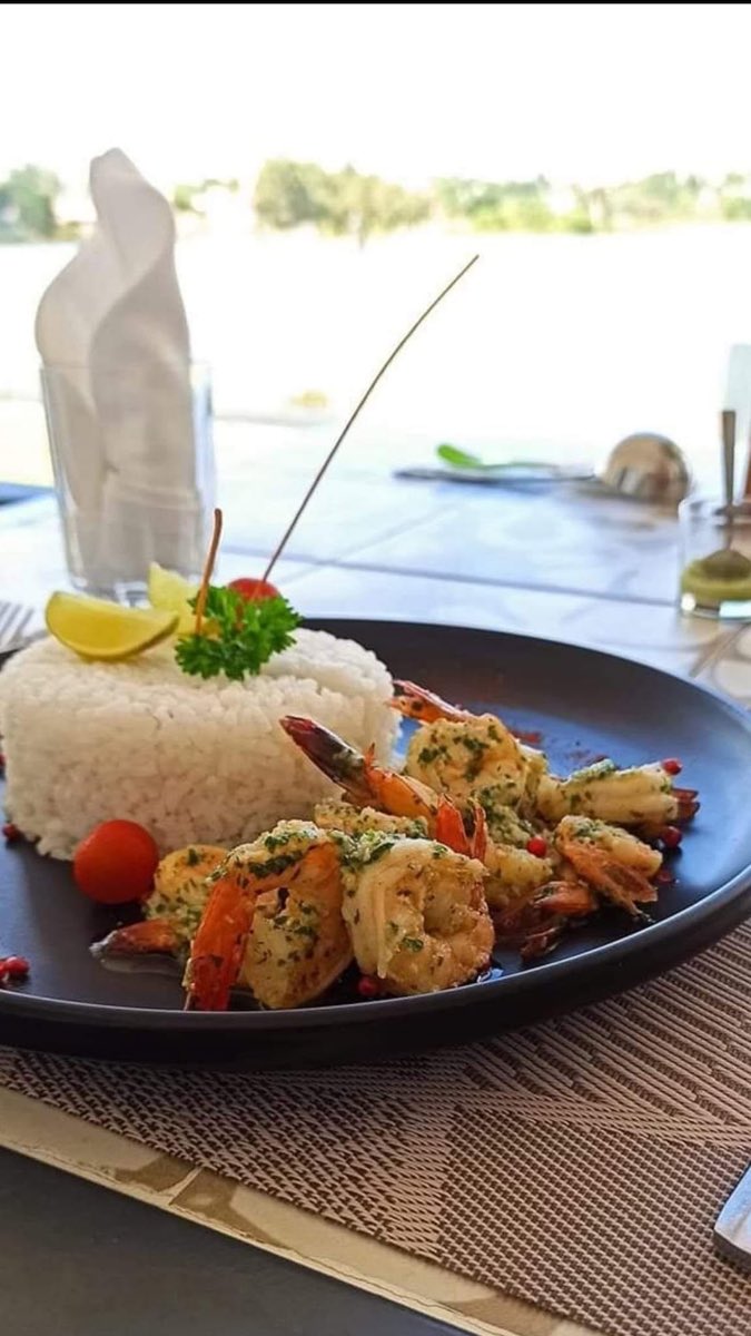 Assiette de crevettes grillées et riz servie face au lac
