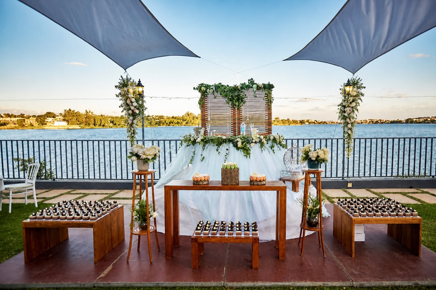Table d’honneur décorée de fleurs et de lanternes au bord du lac